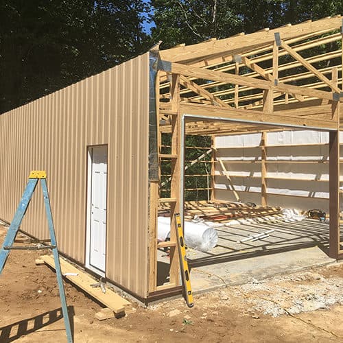 Sanders Construction LLC and Remodeling tan sheet metal building particial built